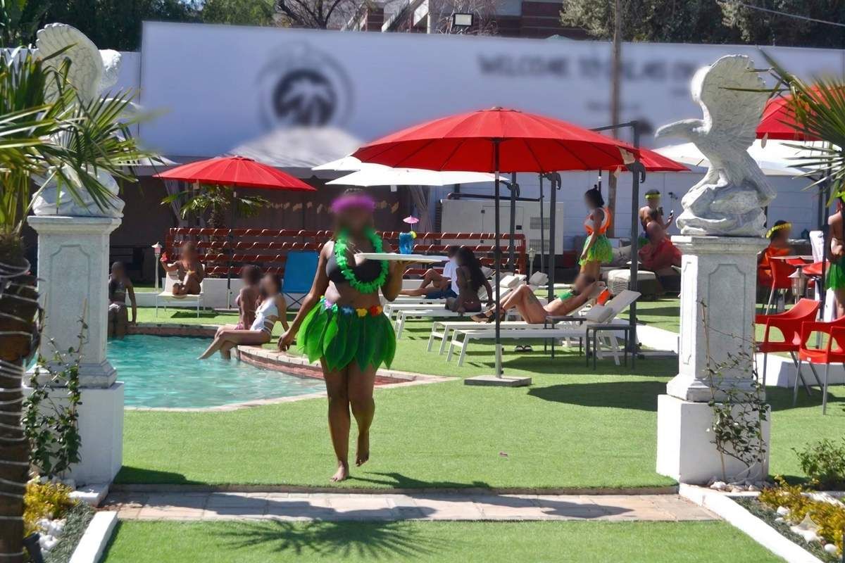 Outdoor pool area featuring a swimming pool, decorative stone pillars, and artificial turf surfacing, suitable for leisure and entertainment.