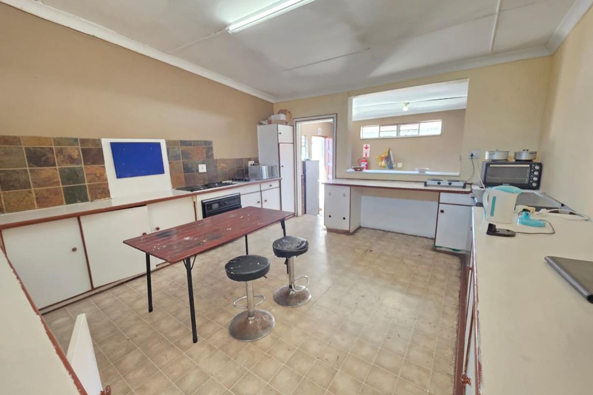 A dated kitchen featuring built-in cabinetry, a tiled splashback, and a built-in oven, offering significant potential for modernization and renovation.