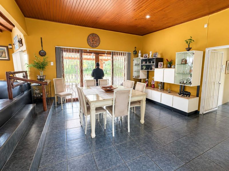Dining room featuring tiled flooring, a timber tongue and groove ceiling, and built-in display cabinetry with access to the outdoor area via sliding doors.