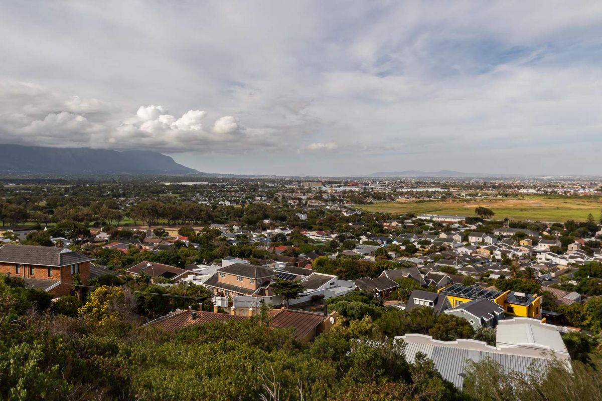 An elevated aerial view overlooking a residential neighborhood with mountain vistas in the distance.