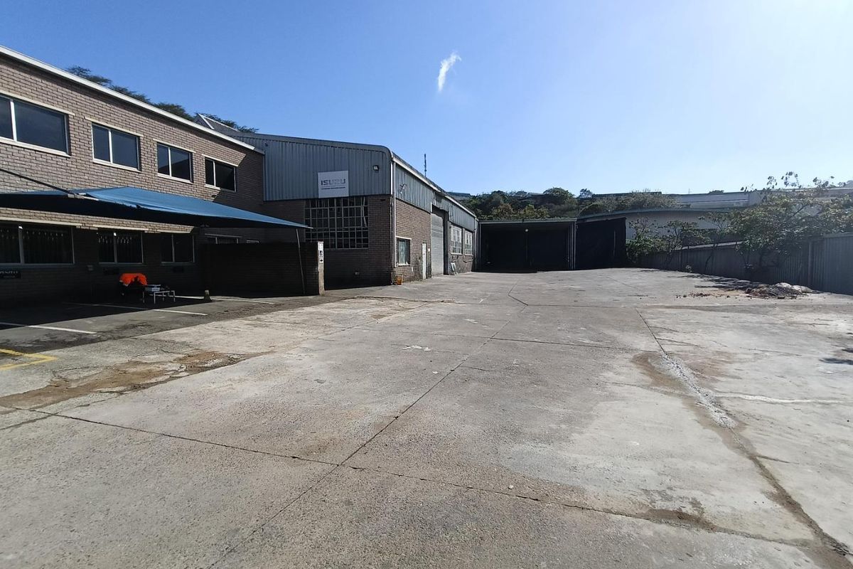 Spacious industrial yard area featuring extensive concrete hardstand, covered parking bays, and direct access to warehouse loading facilities.