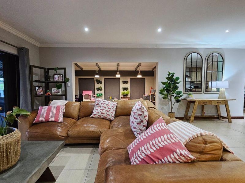 Spacious open-plan living area featuring tiled flooring, recessed downlighting, and large bi-fold doors providing seamless access to the outdoor space.