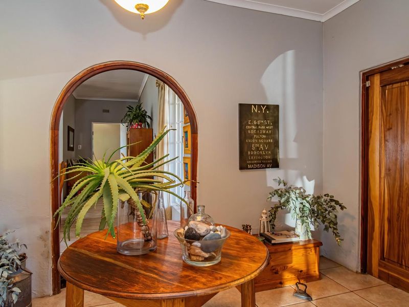 Welcoming entrance hall featuring tiled flooring, a distinctive arched doorway leading to the interior, and a solid wood front door.