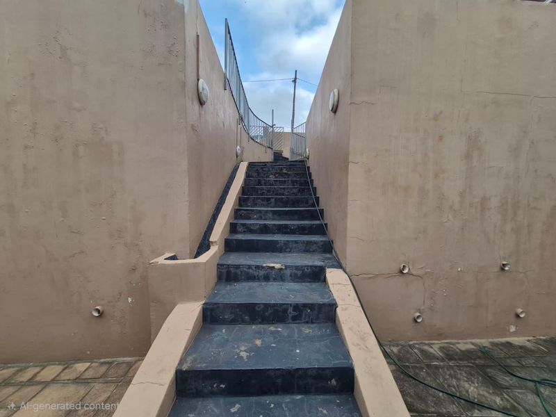 An exterior staircase with metal railings leading upwards, featuring weathered walls and tiled steps showing signs of wear.