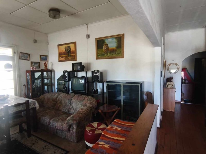 Open plan living and dining area featuring hardwood flooring, an archway transition, and access to an exterior door.