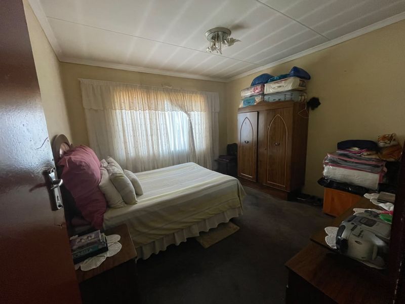 A bedroom featuring carpeted flooring and standard window treatments, offering a functional space ready for cosmetic updates and modernization.