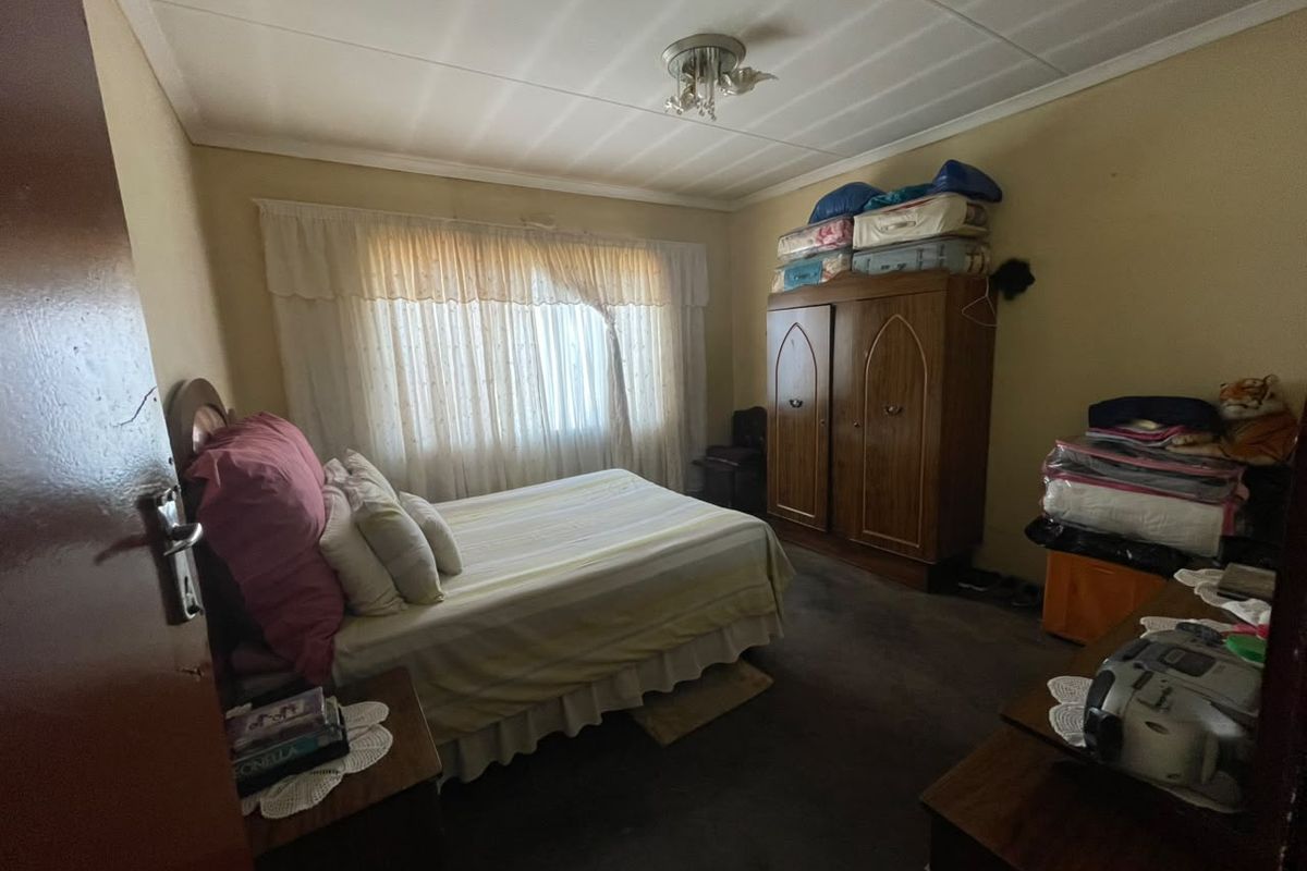A bedroom featuring carpeted flooring and standard window treatments, offering a functional space ready for cosmetic updates and modernization.