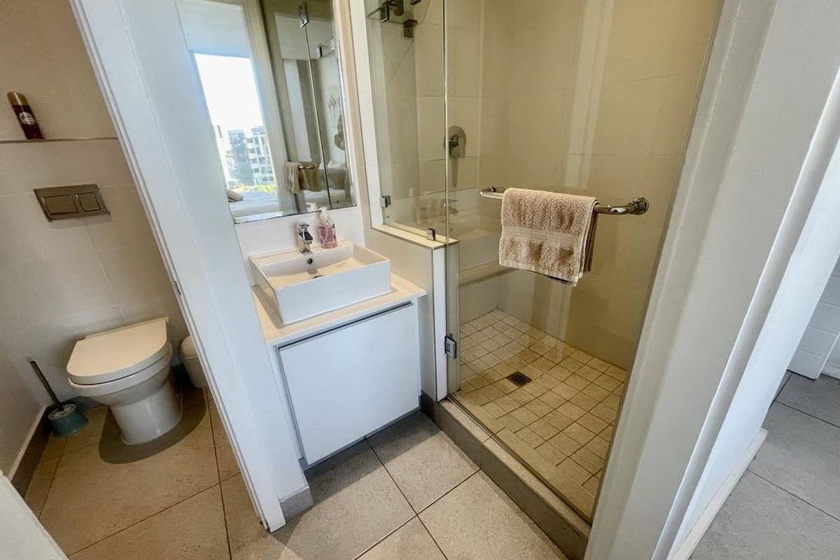 Modern bathroom featuring a glass-enclosed shower, a contemporary vessel sink vanity, and a wall-mounted toilet with a concealed cistern.