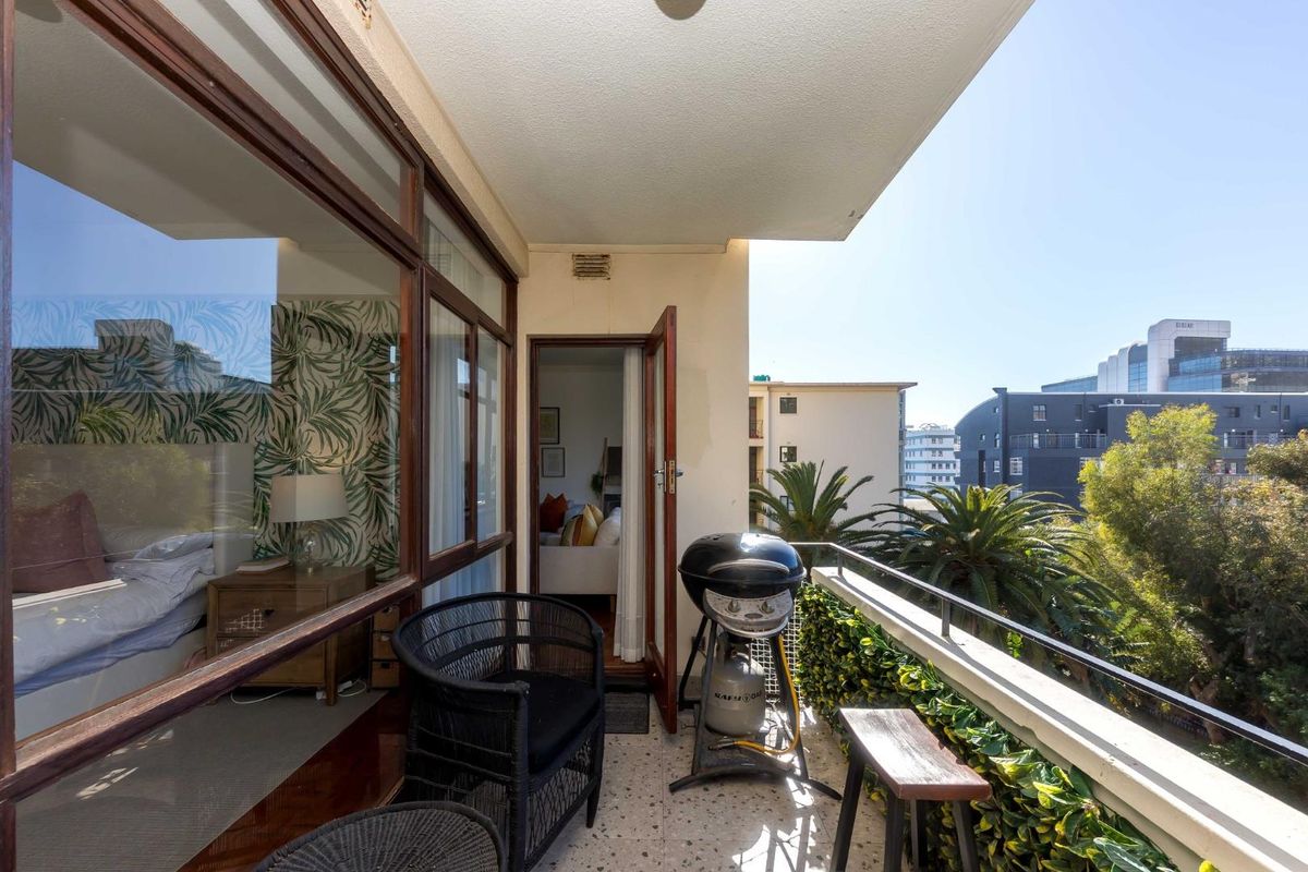 A private balcony featuring terrazzo flooring and metal railings, providing outdoor access from the interior living space with views of the surrounding neighborhood.