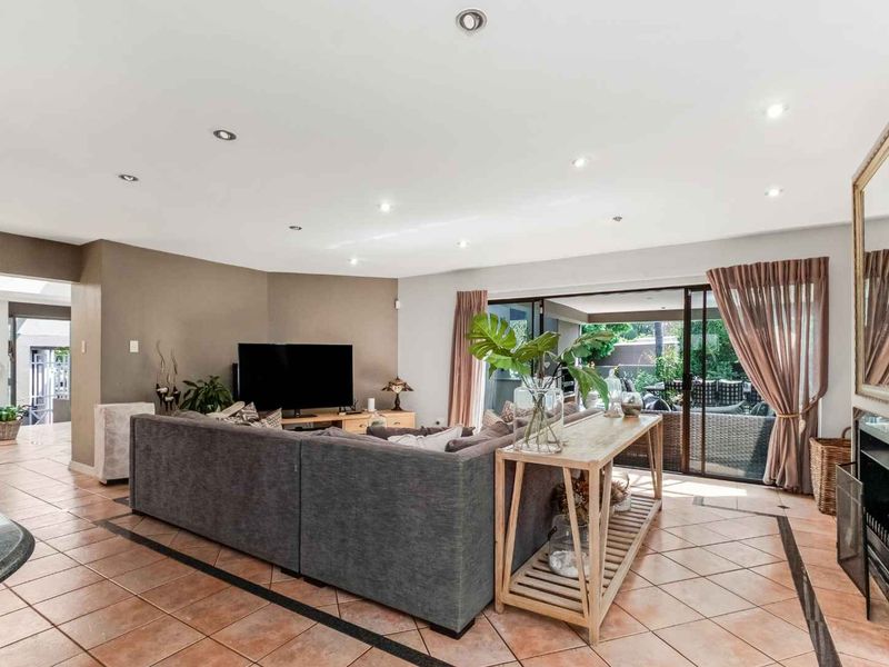 Spacious living room featuring tiled flooring, recessed lighting, a fireplace, and large sliding glass doors providing seamless access to the outdoor patio area.