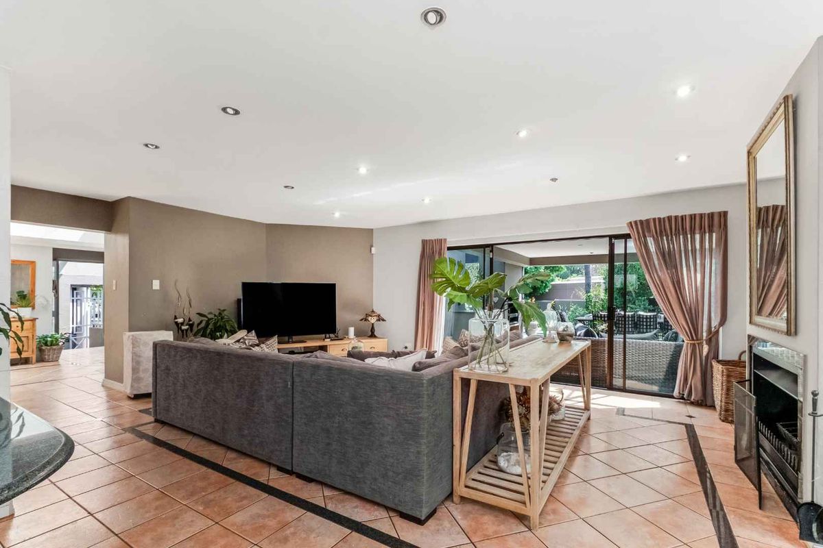 Spacious living room featuring tiled flooring, recessed lighting, a fireplace, and large sliding glass doors providing seamless access to the outdoor patio area.