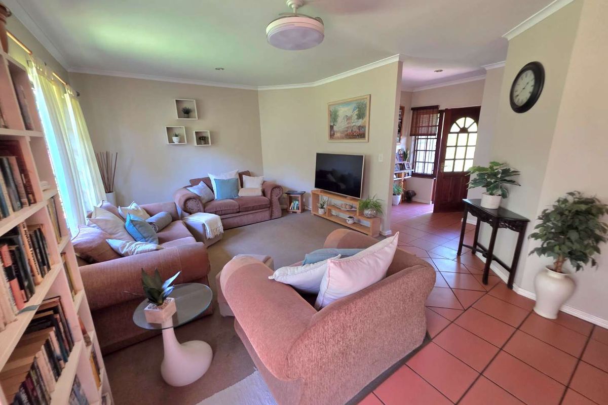 A comfortable living room featuring a mix of tiled and carpeted flooring, coved ceilings, and direct access to the main entrance.