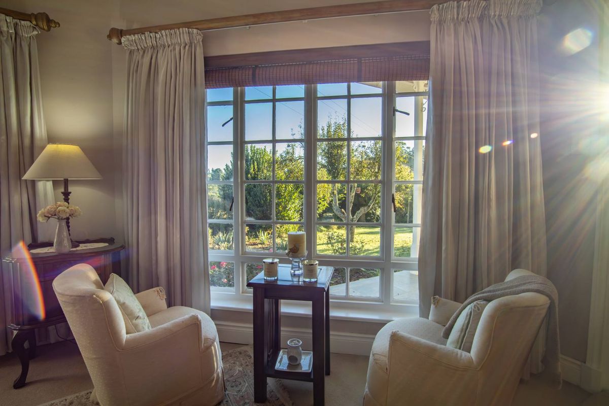 A cozy living area featuring a large multi-pane window that provides ample natural light and views of the surrounding garden.