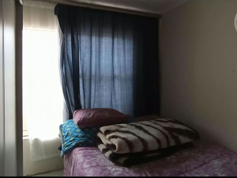 A bedroom featuring a built-in wardrobe and natural light from the window.