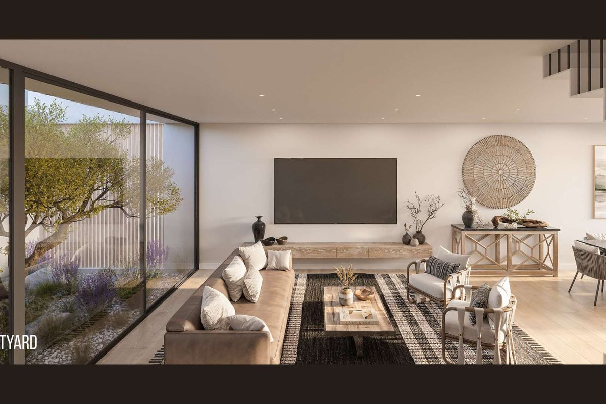 Modern open-plan living area featuring large floor-to-ceiling glass doors overlooking a private courtyard, recessed lighting, and a sleek floating media console.