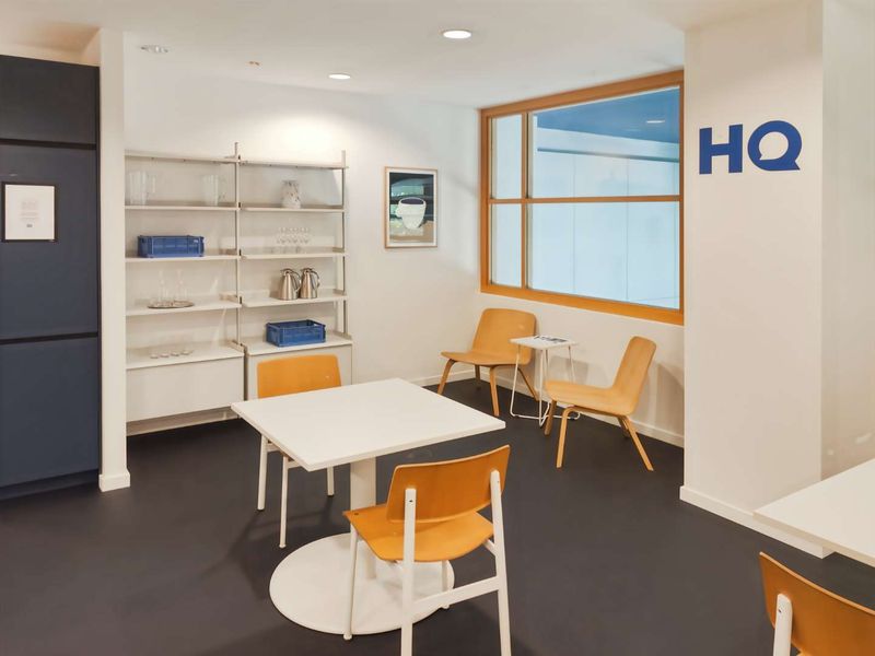 A bright and modern office break-out area featuring recessed lighting, timber-framed windows, and clean, minimalist finishes suitable for a professional workspace.