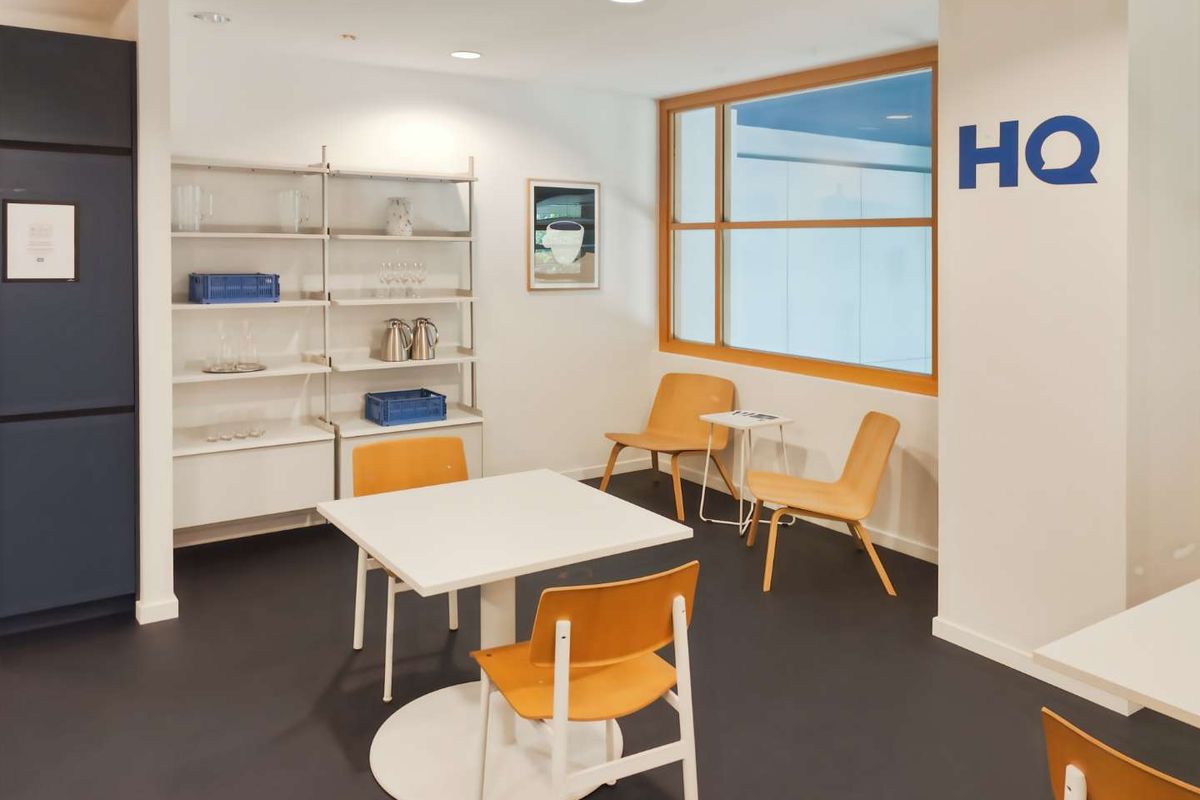 A bright and modern office break-out area featuring recessed lighting, timber-framed windows, and clean, minimalist finishes suitable for a professional workspace.
