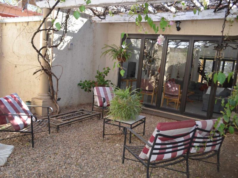 A covered outdoor patio area featuring a pergola structure and large sliding glass doors providing access to the interior living space.