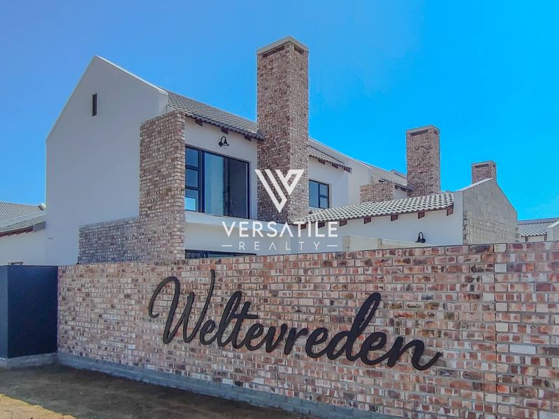 Front elevation of the Weltevreden townhouse complex featuring modern brick architecture, prominent chimney stacks, and a secure perimeter boundary wall.