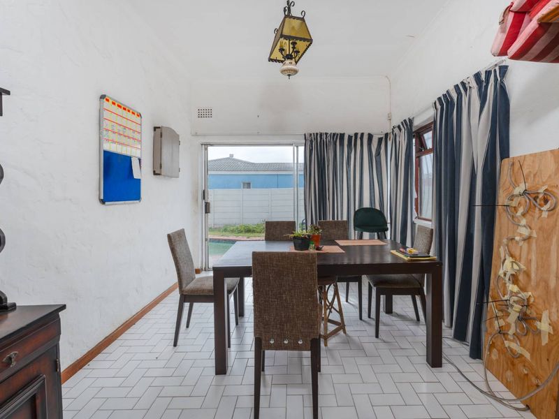 Dining room featuring white tiled flooring and a sliding glass door providing access to the outdoor area.