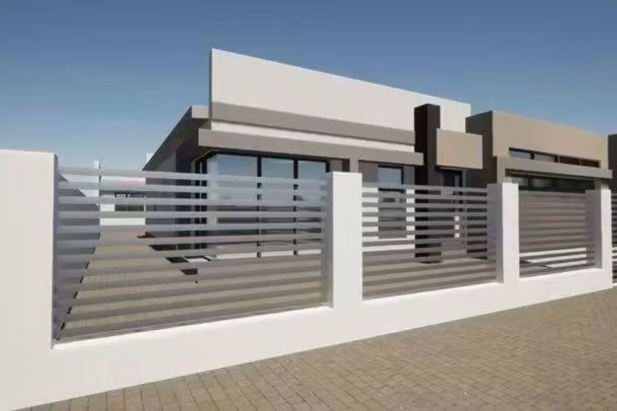 A modern residential property featuring a contemporary facade and a secure horizontal slat metal fence with masonry pillars.
