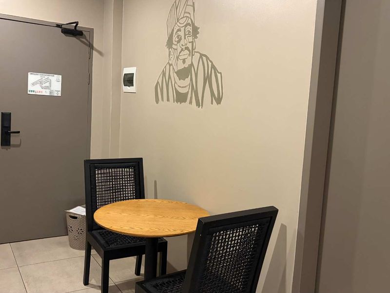 A functional apartment entryway featuring tiled flooring, a secure fire-rated door with a closer, and an integrated intercom system.