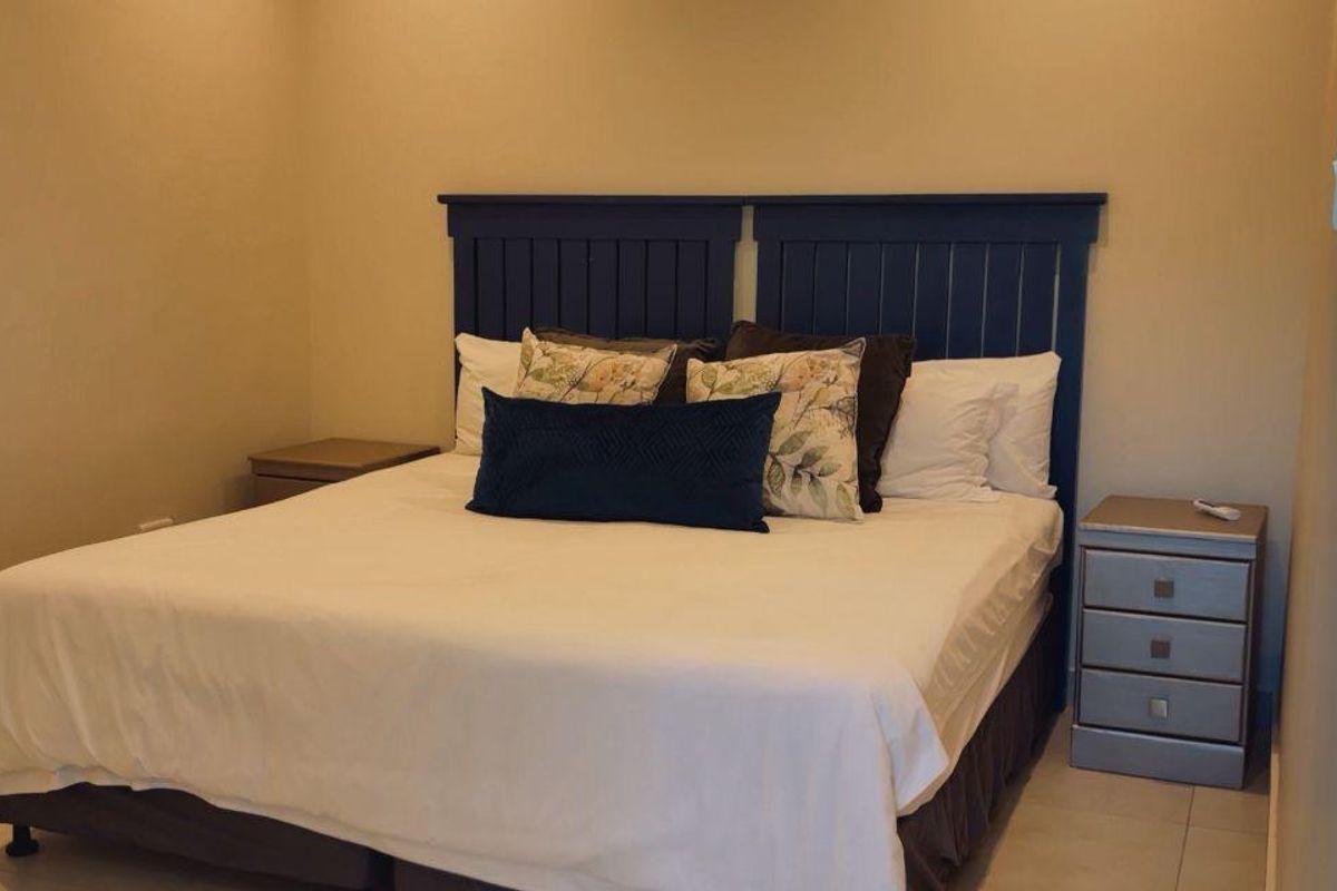 A neutrally painted bedroom featuring tiled flooring and a functional layout, providing a comfortable and quiet sleeping space.