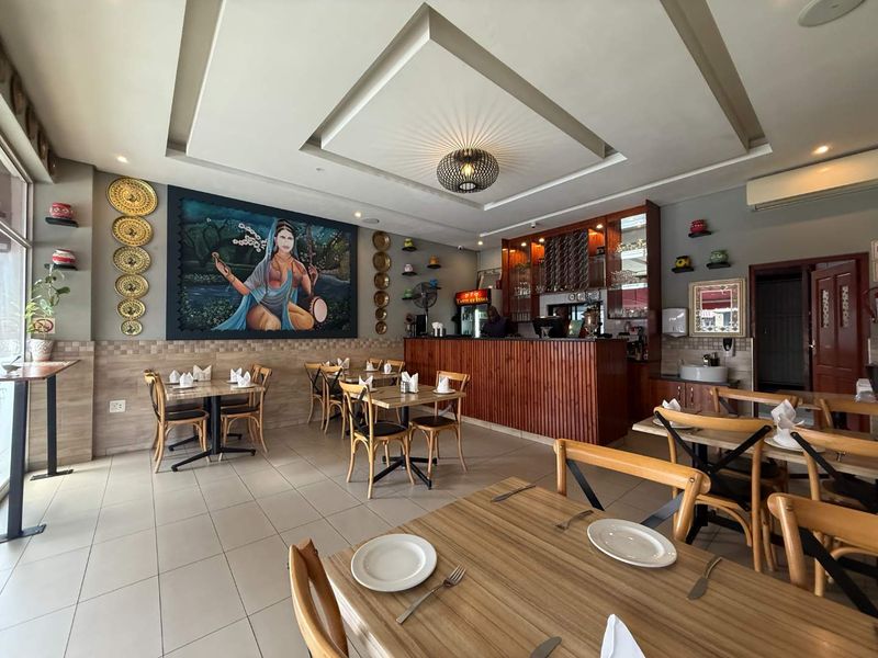 A well-maintained restaurant dining area featuring a built-in bar counter, recessed ceiling lighting, and tiled flooring, suitable for immediate commercial use.