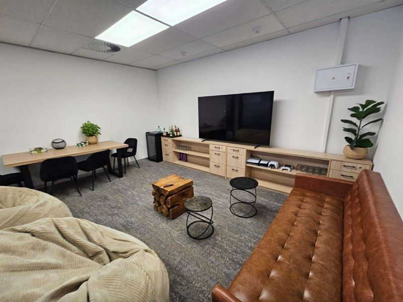A well-maintained office space featuring built-in cabinetry, recessed lighting, and carpeted flooring, suitable for a professional work or breakout area.