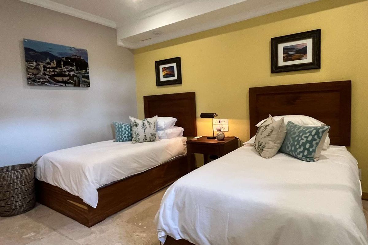 A well-maintained bedroom featuring a dual-tone wall finish, recessed ceiling lighting, and stone flooring, providing a comfortable and functional sleeping space.