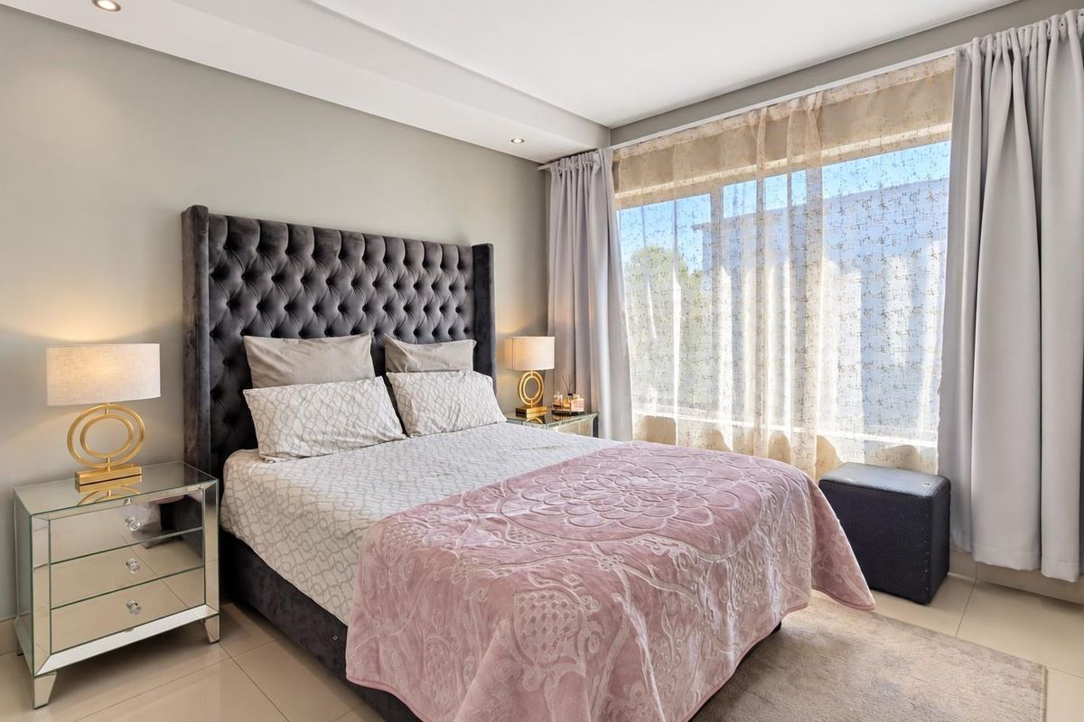 A well-maintained bedroom featuring tiled flooring, recessed downlighting, and a built-in wardrobe, offering a clean and comfortable living space.