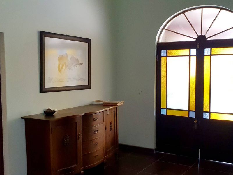 Entrance foyer featuring a distinctive arched stained glass front door and tiled flooring, providing a welcoming transition into the home.