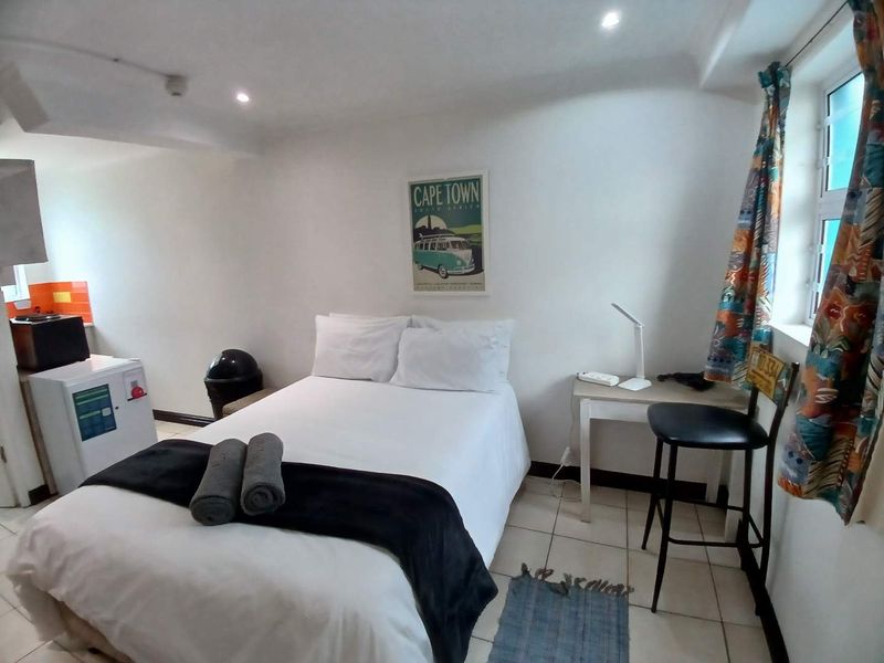 A compact bedroom featuring tiled flooring and recessed downlighting, providing a functional living space.