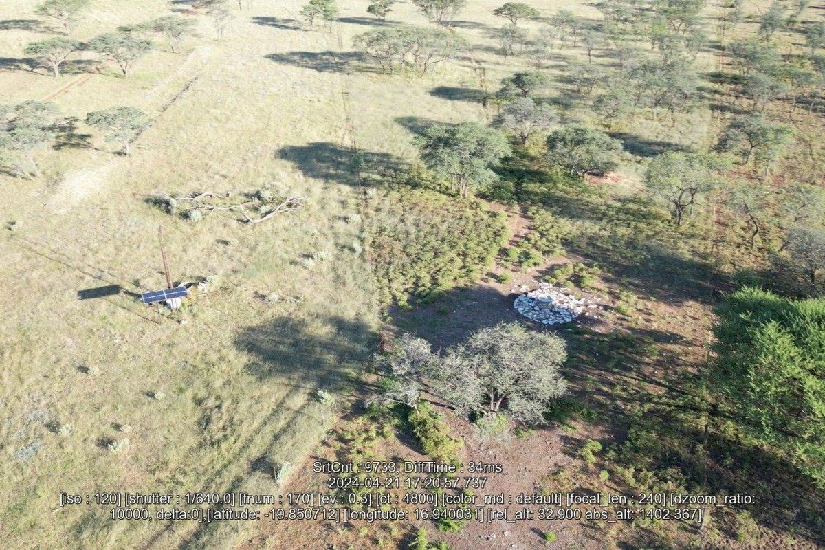 Aerial view of the farm landscape featuring a small solar panel installation and natural vegetation.