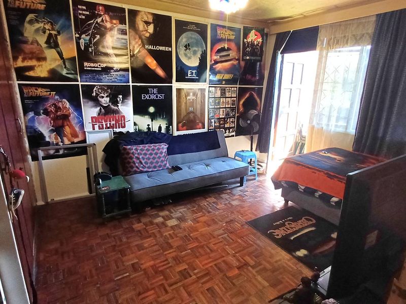A living room featuring classic parquet flooring and direct access to an outdoor area through a security gate.