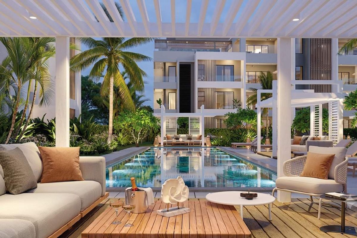 A beautifully landscaped pool area featuring a modern swimming pool, timber decking, and a pergola, set within a contemporary apartment complex.
