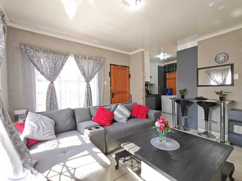 Open-plan living area featuring tiled flooring, a built-in breakfast bar, and direct access to the kitchen space.