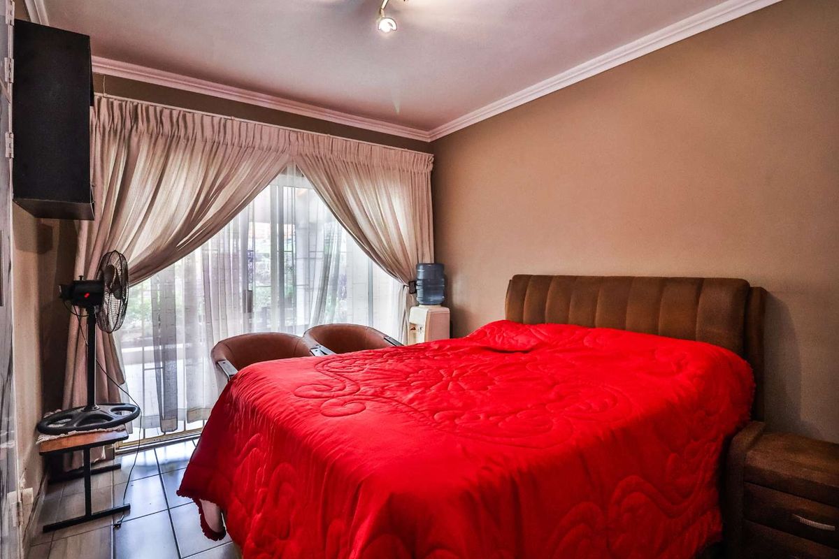 A bedroom featuring tiled flooring, crown molding, and a sliding glass door providing access to the exterior.