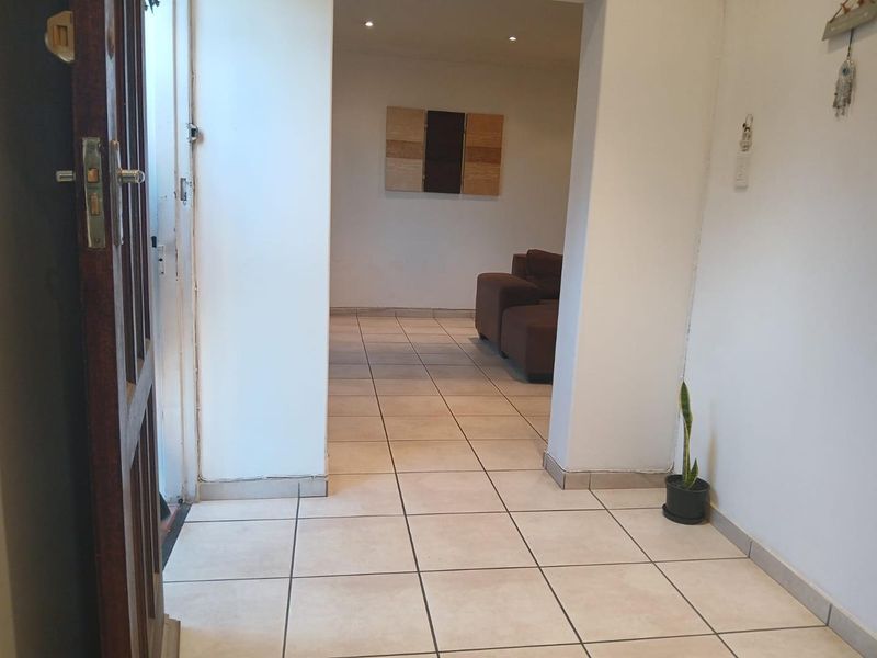 Entrance area featuring neutral tiled flooring and recessed downlighting, providing a clean and functional transition space into the main living area.