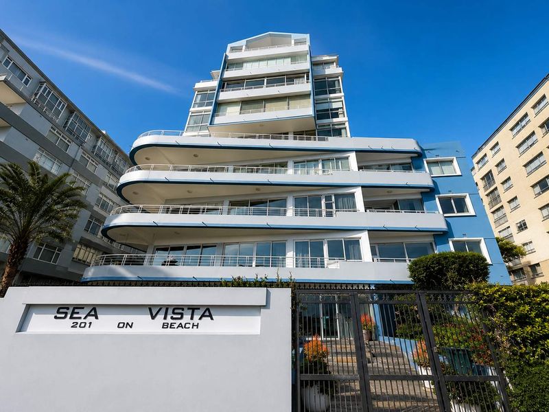 Front elevation of the Sea Vista apartment building, featuring tiered balconies, modern blue and white facade, and secure gated entrance.