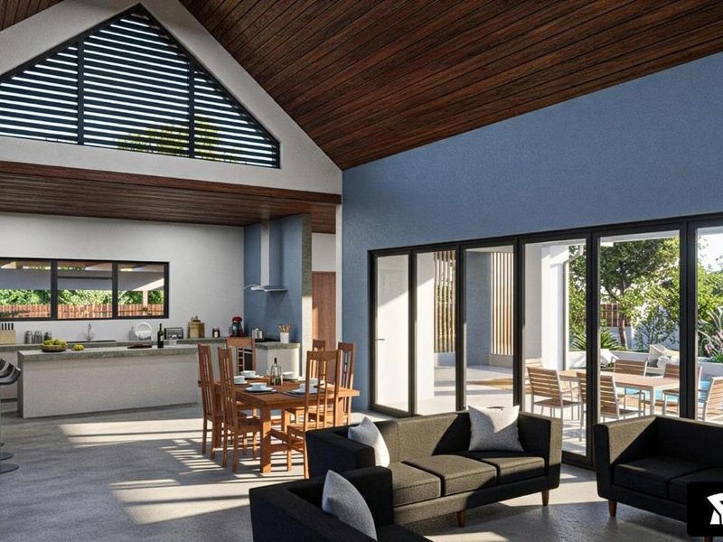 Spacious open-plan living area featuring a modern kitchen, vaulted timber-clad ceilings, and large sliding glass doors opening to a patio and pool area.