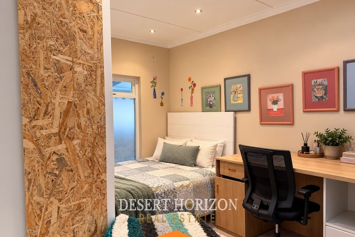 A bedroom featuring a built-in desk and a unique OSB wood panel feature wall, providing a functional and modern aesthetic.