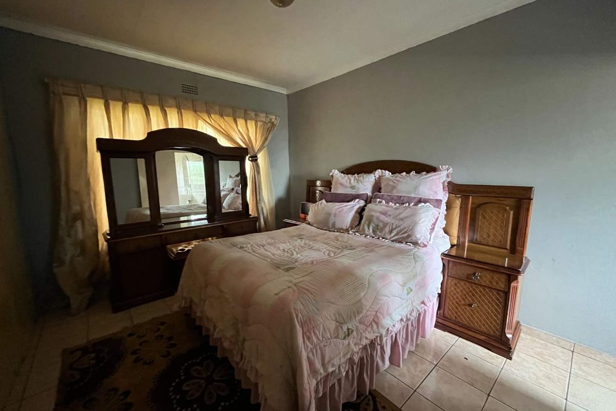 A bedroom featuring tiled flooring and neutral wall finishes, providing a functional space ready for modern updates.
