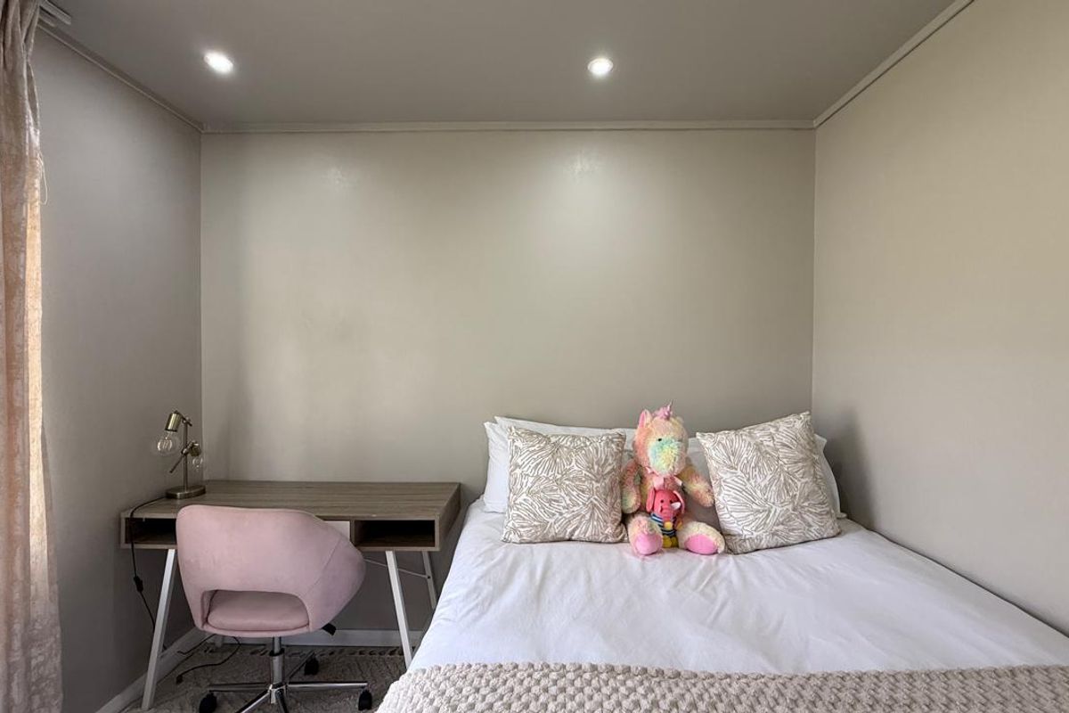 A well-maintained bedroom featuring recessed ceiling lighting and neutral wall finishes, providing a clean and functional living space.