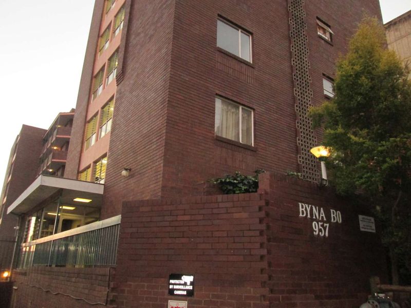 Exterior view of the Byna Bo apartment building featuring a classic red brick facade and secure entrance area.