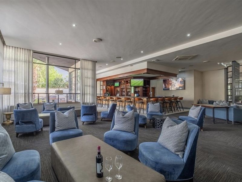 A spacious and well-appointed bar area featuring a large built-in counter, ample lounge seating, and expansive windows providing natural light.
