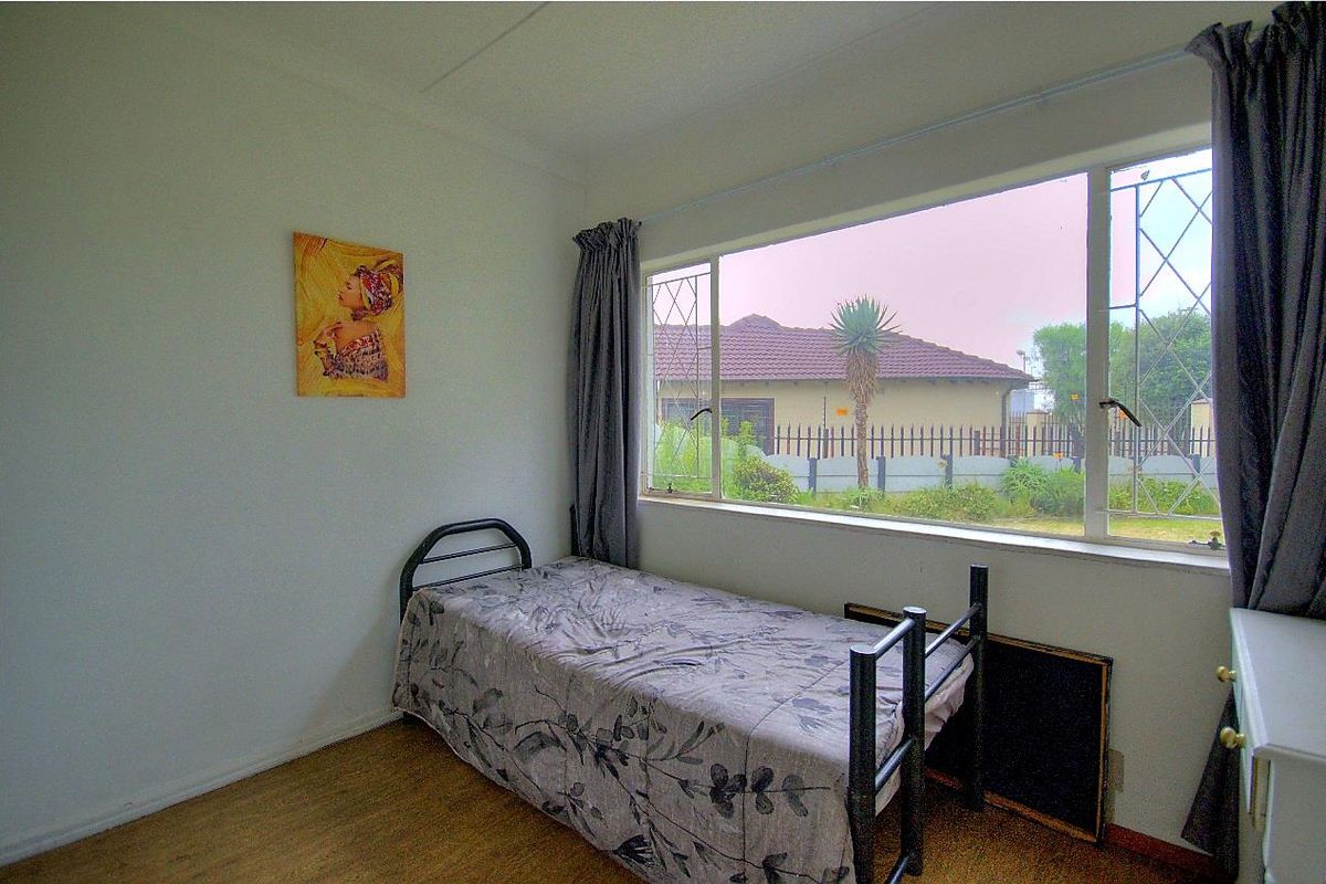 A bedroom featuring large windows that provide natural light and views of the exterior property.