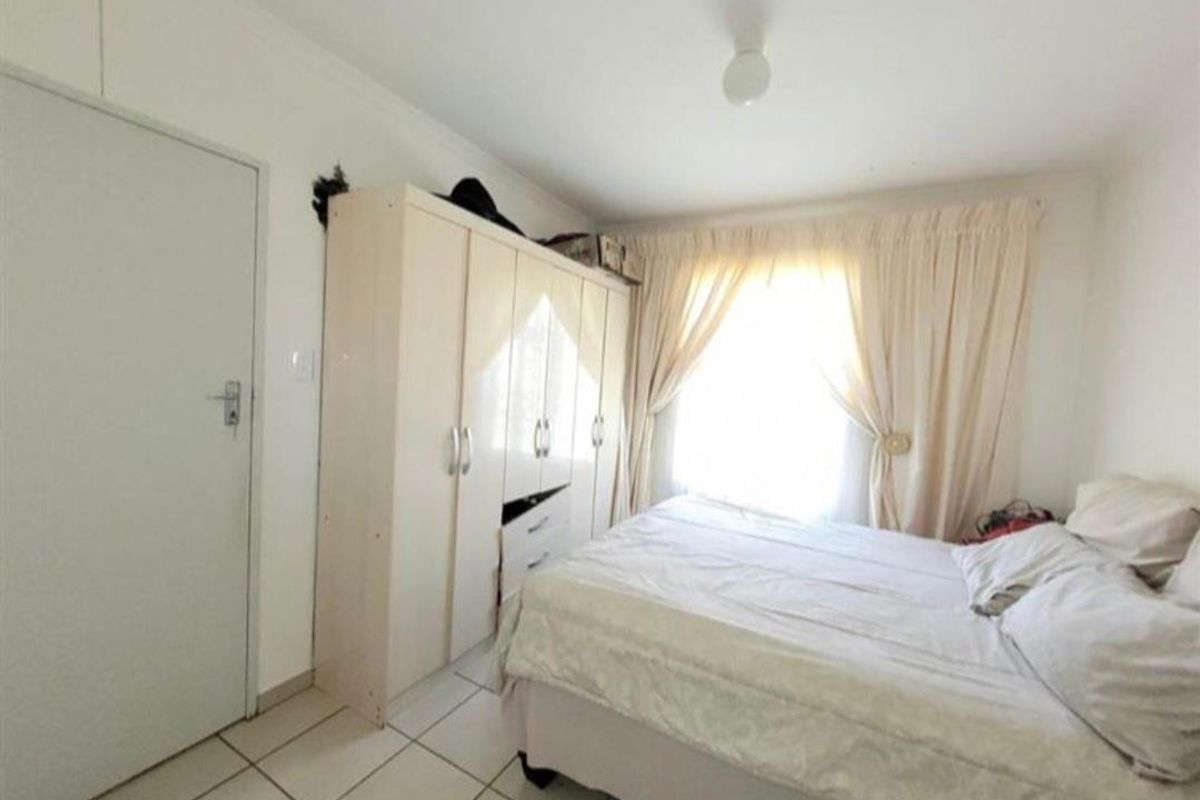 A bedroom featuring tiled flooring and a built-in wardrobe, requiring minor wall repairs to restore the finish.