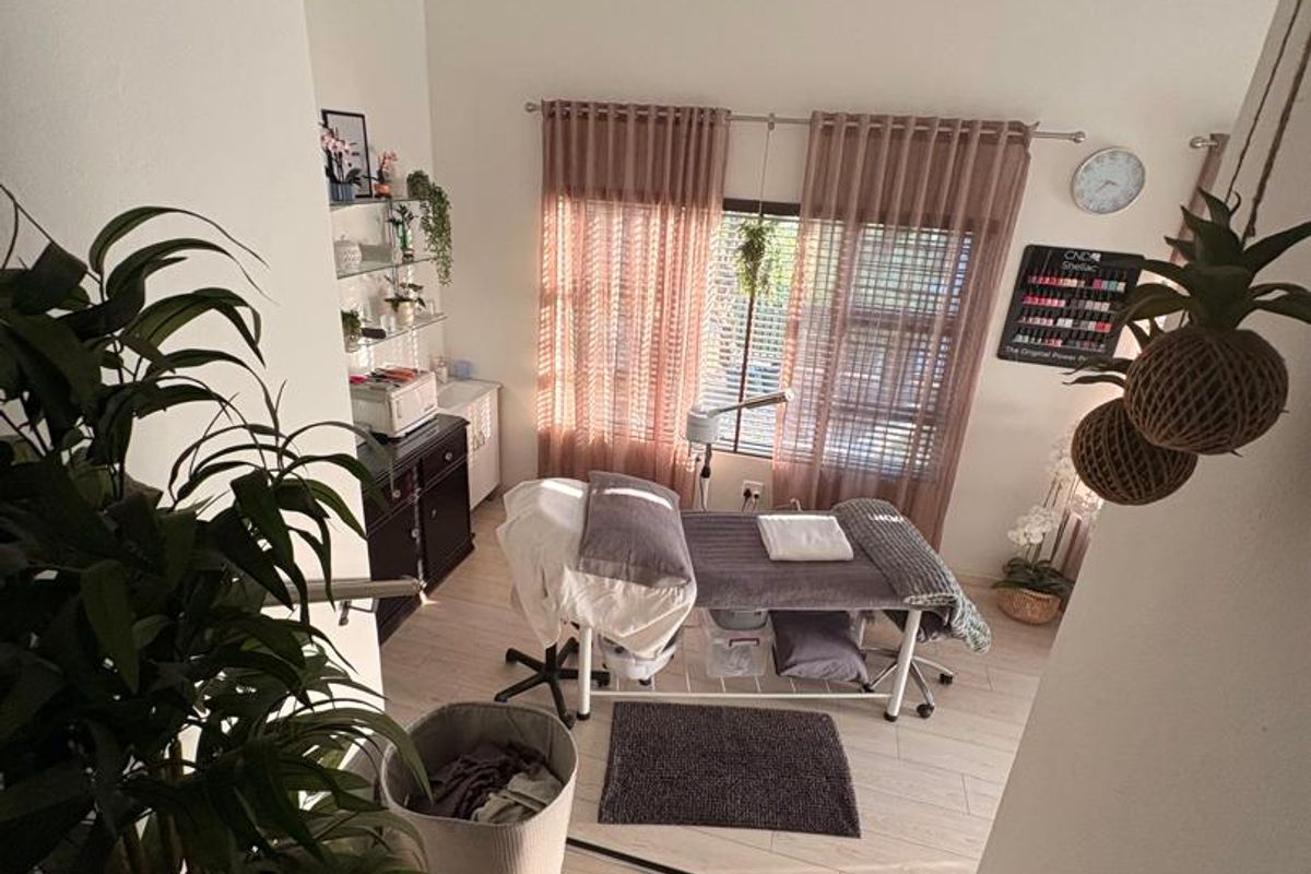 A well-maintained room currently utilized as a beauty treatment space, featuring light timber-look flooring, recessed downlighting, and a tongue and groove ceiling.
