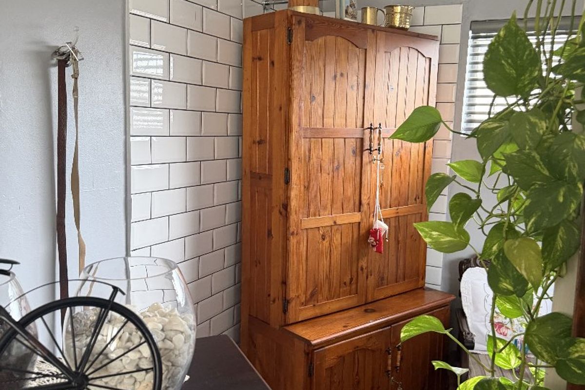 A kitchen corner featuring a white subway tile backsplash, crown molding, and wood-look vinyl flooring.